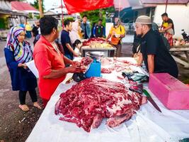 pariaman, Indonesia - abril 9, 2024. ocupaciones de carne vendedores y los compradores a el ganado mercado, un tradicion a Bienvenido eid al-fitr en el ciudad de pariaman foto
