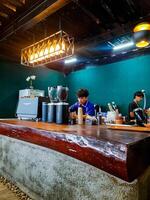 Solok, Indonesia - April 14, 2024. a barista and a cashier taking customer orders at a coffee shop in the Puncak Cambai tourist spot in Alahan Panjang. photo