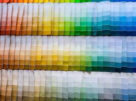 paper color palettes on a shelf in a wall paint supply store, guide of paint samples catalog photo