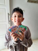 A boy who has received a certain amount of holiday allowance on Eid al-Fitr in Indonesia photo