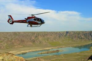 Helicopter flying over the river photo