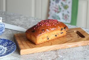 Closeup of raisin muffin on olive wood board in kitchen. photo