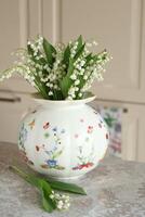 Bouquet of lilies of valley in vase indoor photo