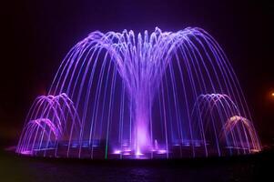 Coloured water fountain at night photo