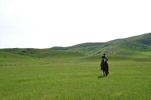 The little girl with the daddy go for a drive on a horse in steppe photo