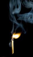 Wooden match burning on a black background photo