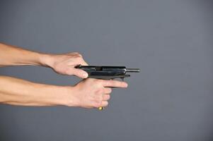 Hand with gun isolated on grey background photo