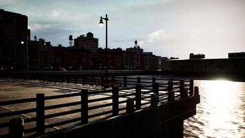 The sun shines brightly on the water near a bridge video