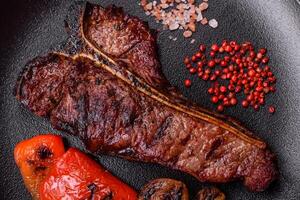 Delicious juicy beef tbone steak with salt, spices and herbs photo