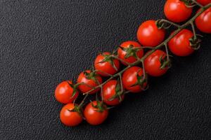 A sprig of ripe red cherry tomatoes as an ingredient for cooking at home photo