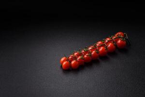 A sprig of ripe red cherry tomatoes as an ingredient for cooking at home photo