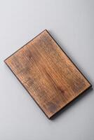 Empty wooden cutting board on gray textured concrete background photo