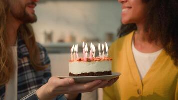 multirazziale coppia multietnico diversità persone sposato caucasico uomo fidanzato Tenere torta per africano americano compleanno donna fidanzata desiderio soffiaggio candele Congratulazioni celebrazione a casa video