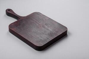 Empty wooden cutting board on gray textured concrete background photo