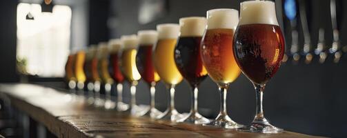 A row of glasses with different types and colors beer, sitting on the bar counter photo