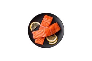 Fresh raw salmon steak with spices and herbs prepared for grilled baking photo