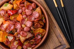 Grilled potatoes cut into slices with hunting sausages with garlic, onion photo