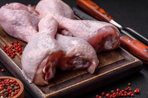 Fresh raw chicken legs with salt and spices photo