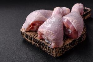 Fresh raw chicken legs with salt and spices photo