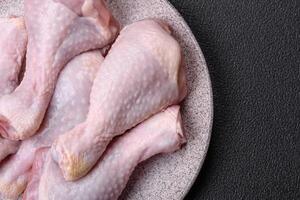 Fresh raw chicken legs with salt and spices photo