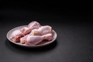 Fresh raw chicken legs with salt and spices photo