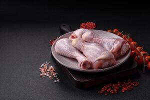 Fresh raw chicken legs with salt and spices photo