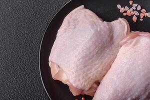 Fresh raw chicken thighs with salt and spices photo