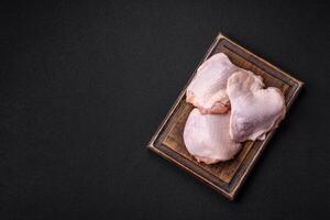 Fresh raw chicken thighs with salt and spices photo