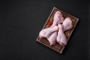 Fresh raw chicken legs with salt and spices photo