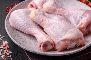 Fresh raw chicken legs with salt and spices photo