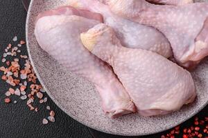 Fresh raw chicken legs with salt and spices photo