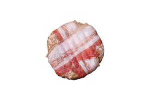 Round minced chicken or pork cutlet wrapped in bacon with salt, spices and herbs photo