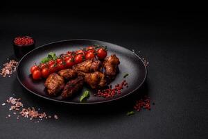 Delicious juicy chicken wings baked on the grill with salt, spices and herbs photo