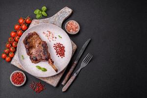 Delicious juicy beef steak on the bone, tomahawk with salt, spices and herbs photo