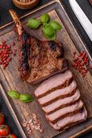 Delicious juicy beef steak on the bone, tomahawk with salt, spices and herbs photo