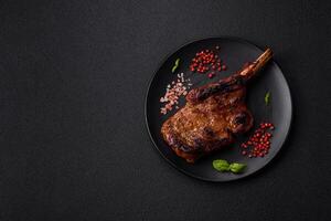 Delicious juicy beef steak on the bone, tomahawk with salt, spices and herbs photo