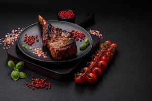 Delicious juicy beef steak on the bone, tomahawk with salt, spices and herbs photo