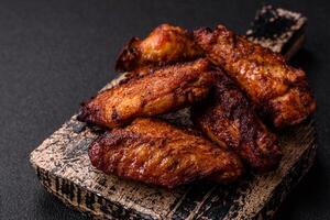 Delicious juicy chicken wings baked on the grill with salt, spices and herbs photo