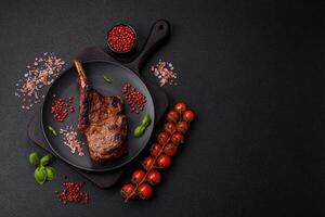 Delicious juicy beef steak on the bone, tomahawk with salt, spices and herbs photo