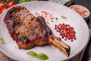 delicioso jugoso carne de vaca filete en el hueso, tomahawk con sal, especias y hierbas foto