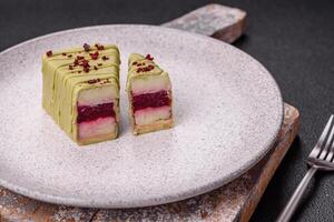 Delicious sweet cheesecake with fruits covered with icing with a wooden stick photo