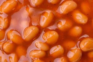 Delicious nutritious canned beans in tomato, with salt and spices photo