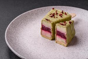 Delicious sweet cheesecake with fruits covered with icing with a wooden stick photo