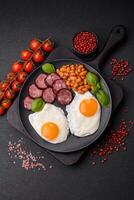 English breakfast with fried eggs, bacon, beans, tomatoes, spices and herbs photo