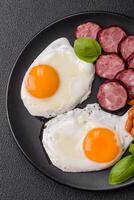 English breakfast with fried eggs, bacon, beans, tomatoes, spices and herbs photo