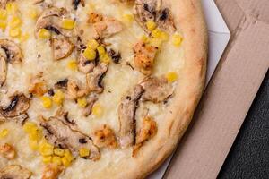 Delicious pizza with corn, cheese, tomatoes and mushrooms, salt, spices and herbs photo