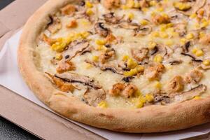 Delicious pizza with corn, cheese, tomatoes and mushrooms, salt, spices and herbs photo