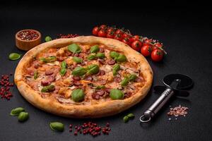 Delicious pizza with sausage, cheese, tomatoes, salt, spices and herbs photo