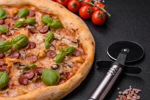 Delicious pizza with sausage, cheese, tomatoes, salt, spices and herbs photo