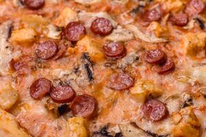 Delicious pizza with sausage, cheese, tomatoes, salt, spices and herbs photo